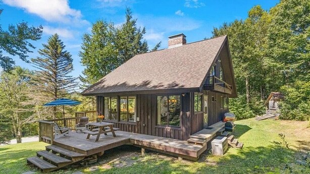 A cabin with a deck, a chimney, and a large window. - a Vermont mountain adventure cabin (Cambridge)
