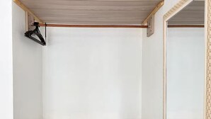 Een kamer met een houten vloer, witte muren en een zwart hangrek.