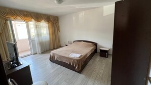 Een slaapkamer met een bed, een bureau, een stoel en een televisie.