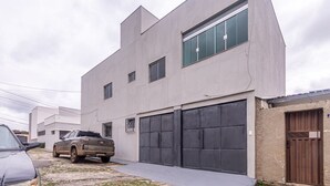 A modern two-story building with a garage, a parked truck, and a gated entrance.