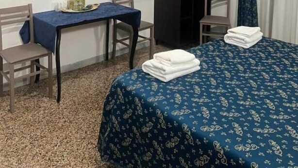 A room with a bed, a desk, a chair, a television mounted on the wall, and a wardrobe. - ines downtown (Rome)