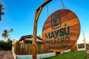 A wooden sign with the text 'MAYSÚ PATACHO' and a Wi-Fi symbol.