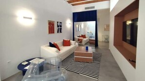 Un salon moderne avec un canapé blanc, une table basse et un tapis à rayures.