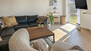 A living room with a sofa, coffee table, and a TV. - Beautiful home in Blokhus with WiFi (Blokhus)