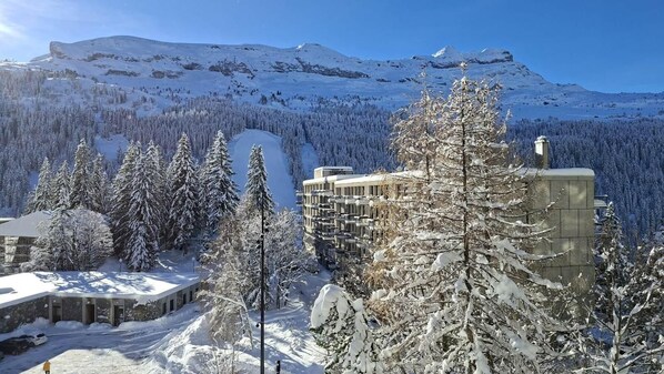 Eine verschneite Berglandschaft mit einem Gebäude im modernen Baustil.