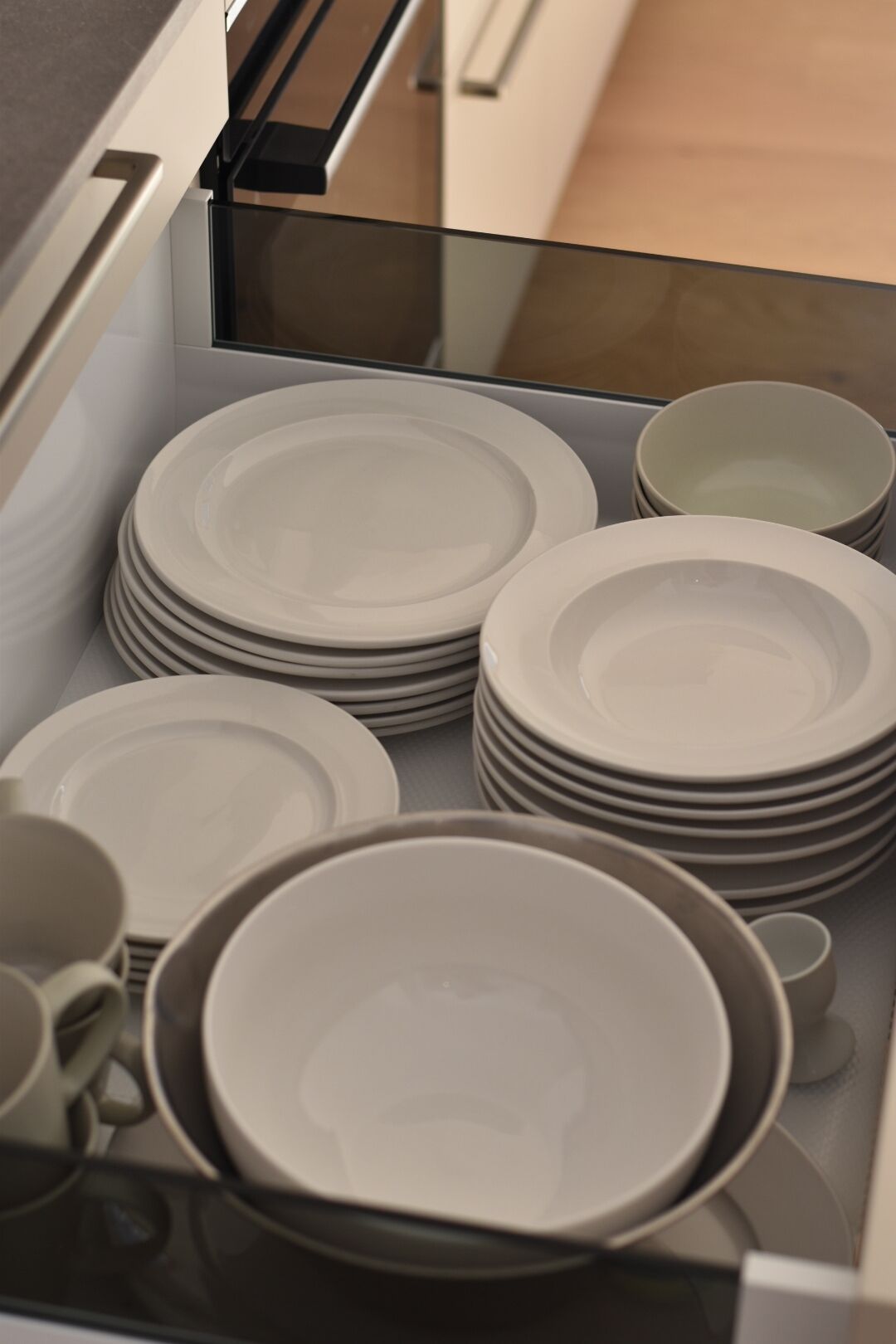 A kitchen drawer with neatly stacked plates and bowls.