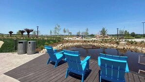 Een terras met blauwe stoelen en een kleine vijver.
