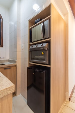 Een keuken met een ingebouwde oven, magnetron en koelkast.