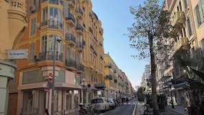 Una calle con edificios de varios pisos, una señal de prohibido el paso y un paso de peatones.