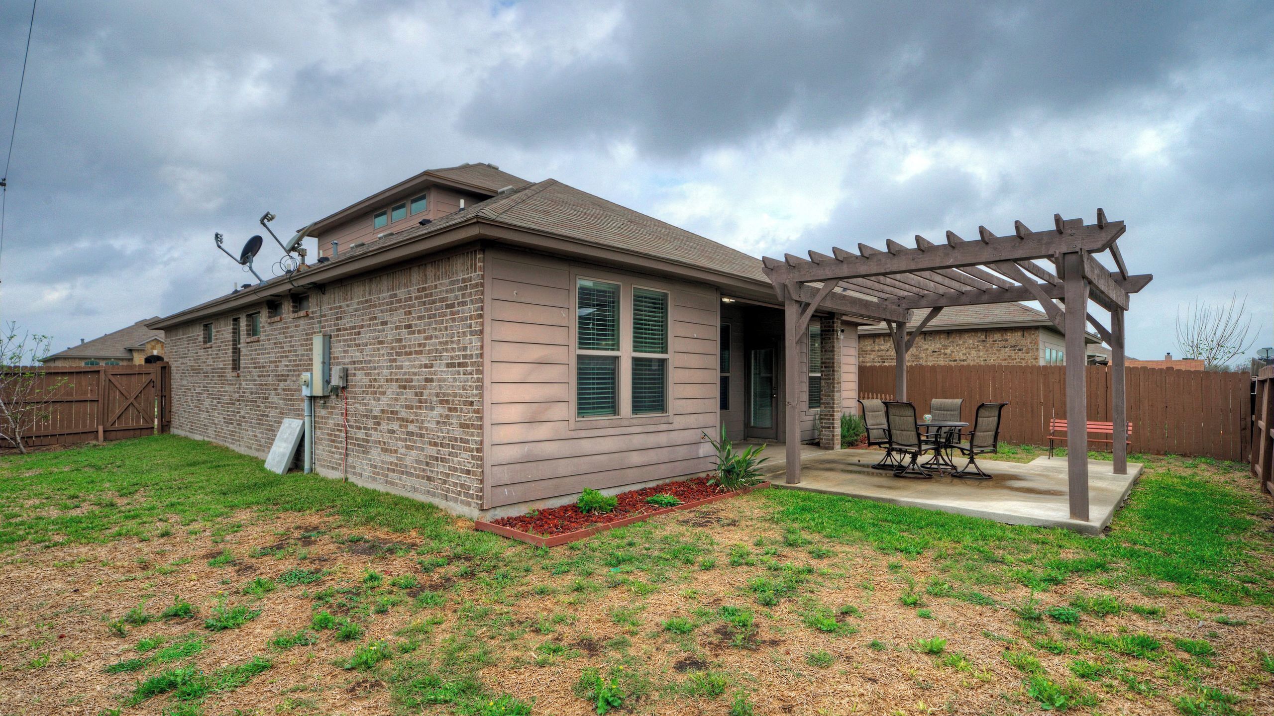 A single-story house with a patio and a fenced backyard.