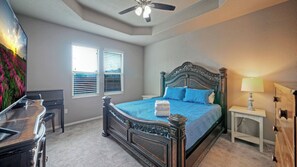 A bedroom with a bed, a desk, a dresser, a ceiling fan, and two windows with blinds. - Rhumba by Avantstay Game Room + Bakyard Oasis + Outdoor Dining Near Beaches and Downtown (Corpus Christi)
