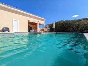 En swimmingpool med ett hus i bakgrunden.
