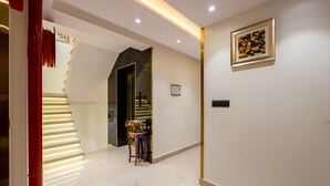 Een modern interieur met een trap, een ingelijste afbeelding en een klein tafeltje met een decoratief object.