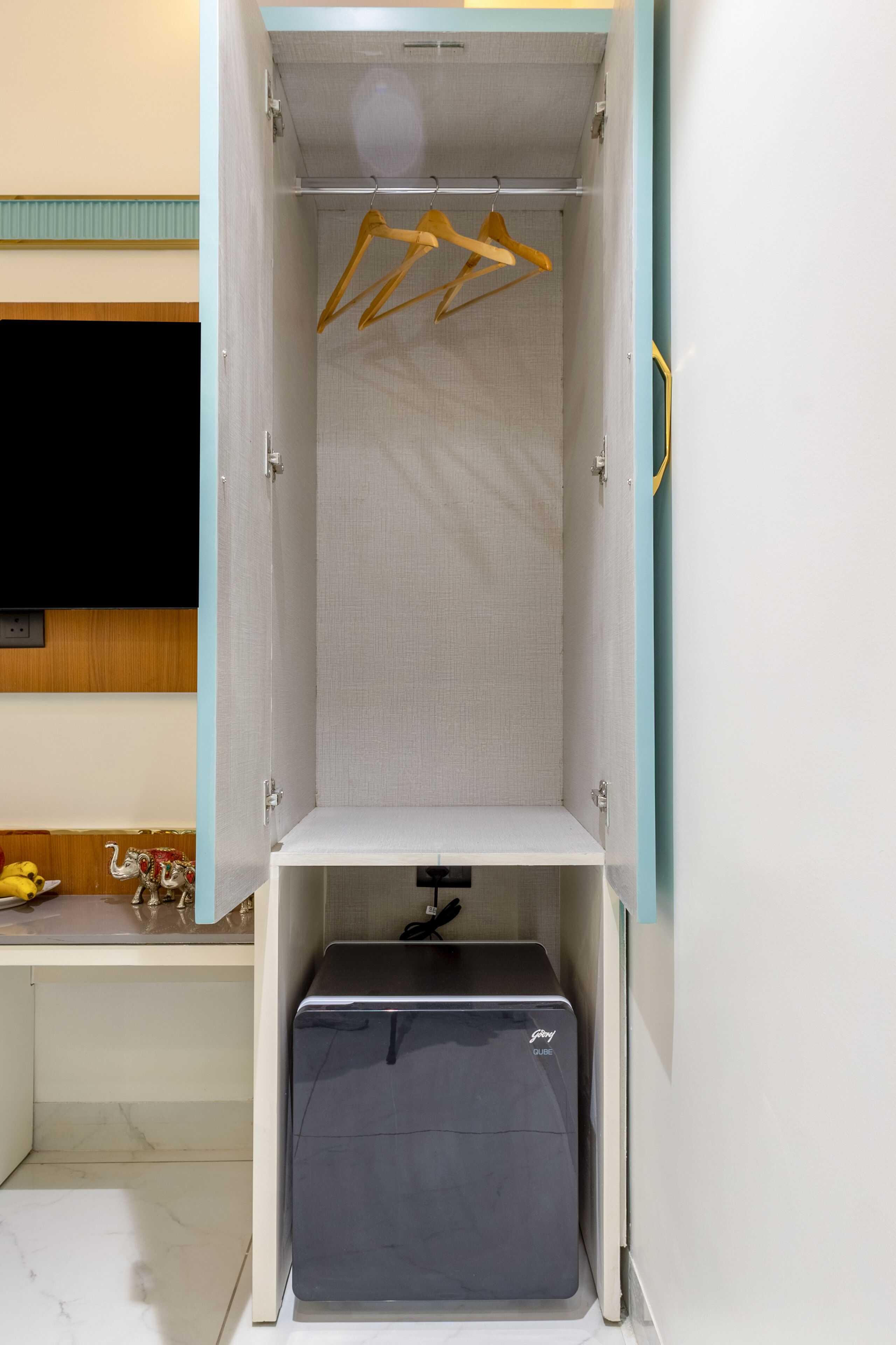 A wardrobe with hanging space and a storage compartment.