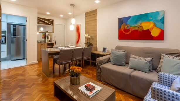 Uma sala de estar moderna com sofá, mesa de centro e área de jantar.
