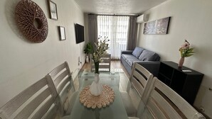 Fjölskylduíbúð - 3 svefnherbergi - loftkæling - borgarsýn | Stofa | 42-tommu flatskjársjónvarp með stafrænum rásum