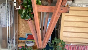 Une pièce dotée d’une structure de plafond en bois, d’un canapé et d’une étagère contenant divers objets.
