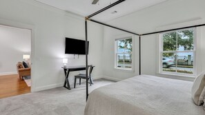 A bedroom with a bed, a desk, a chair, a TV, and large windows. - 13 Condos in the Historic District Entire Building The Juliette by Avantstay (Savannah)