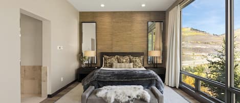 Un dormitorio con una cama grande, vistas al exterior y un diseño moderno.