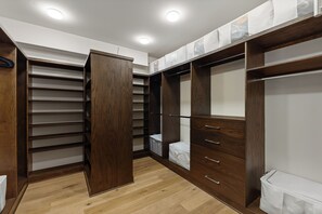 A walk-in closet with wooden shelving, drawers, and hanging space. - Charming 5-Bedroom Home w/ Private Spa and A/C in Beautiful West Vail (Vail)
