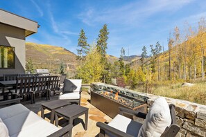 An outdoor patio with stone flooring, a fire pit, and a view of a mountainous landscape. - Charming 5-Bedroom Home w/ Private Spa and A/C in Beautiful West Vail (Vail)