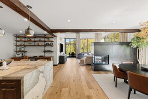 A modern kitchen with wooden beams, a marble countertop, and a built-in fireplace. - Charming 5-Bedroom Home w/ Private Spa and A/C in Beautiful West Vail (Vail)