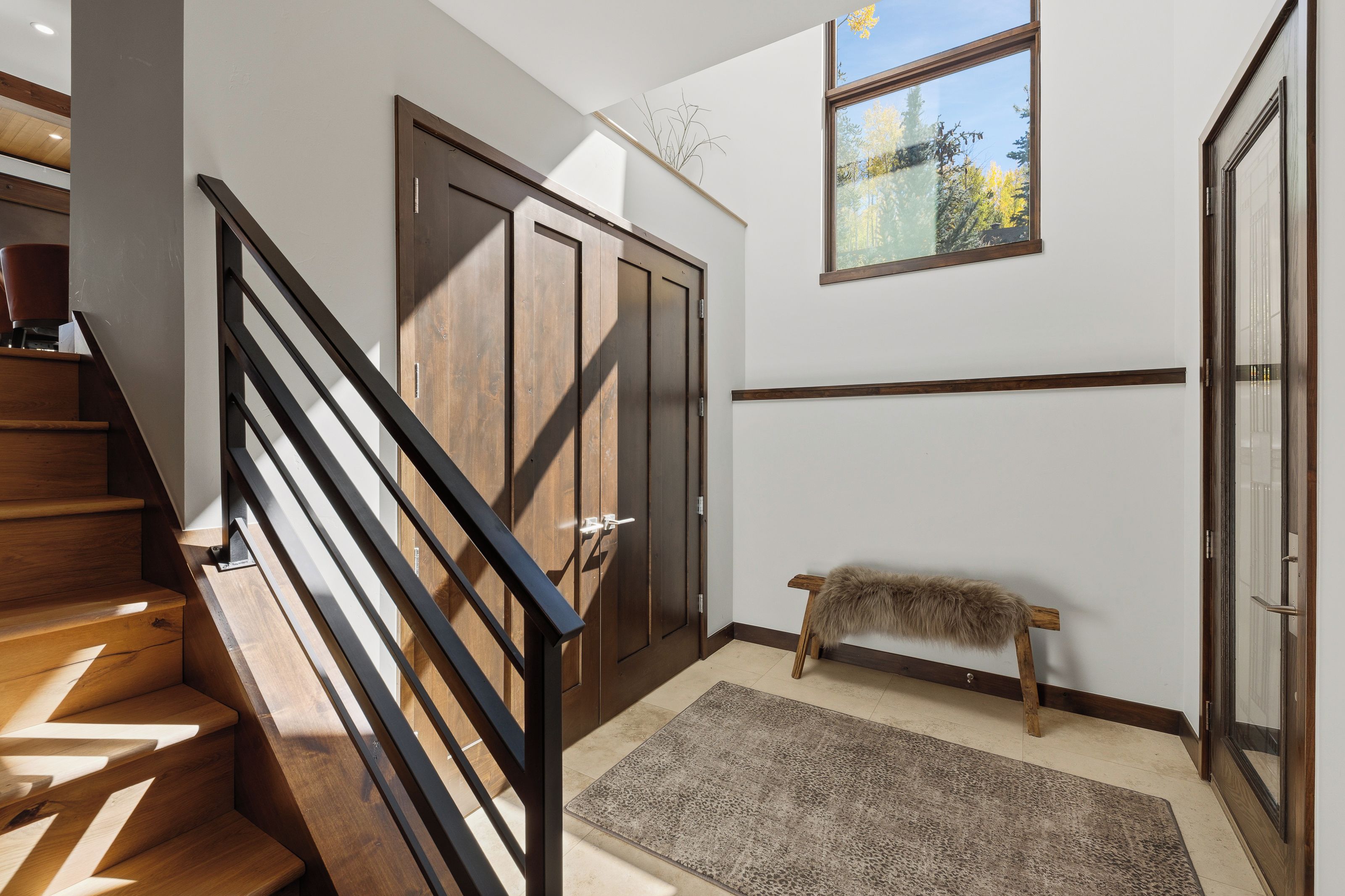 A staircase with wooden steps and black railings leading to a door with a wooden frame.