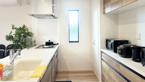A modern kitchen with a built-in stove, a window, and a coffee maker. - Akikawa Waifu 2 | 25 min to TSMC | Entire 4LDK House | Up to 8 Guests (菊池市)