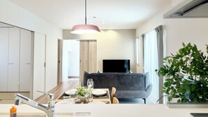 A modern kitchen with a dining area, a TV, and a plant. - Akikawa Waifu 2 | 25 min to TSMC | Entire 4LDK House | Up to 8 Guests (菊池市)
