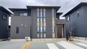 A modern building with a central entrance, large windows, and a gravel driveway. - Akikawa Waifu 2 | 25 min to TSMC | Entire 4LDK House | Up to 8 Guests (菊池市)