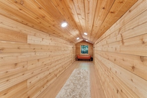 A narrow wooden hallway with a bench and a window at the end. - Spacious 7-bedroom cabin with AC in charming Stockbridge (Stockbridge)