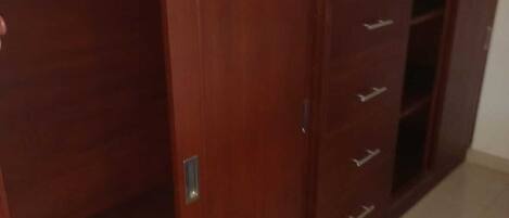 A room with a wardrobe, a door, and a tiled floor.