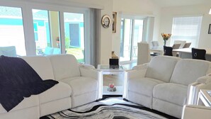 Un soggiorno moderno con divano, tappeto decorato e zona pranzo con tavolo e sedie.