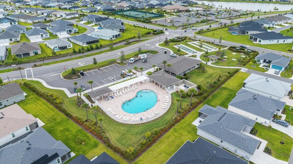 Vue aérienne d’un quartier résidentiel avec des maisons, des routes et une piscine.