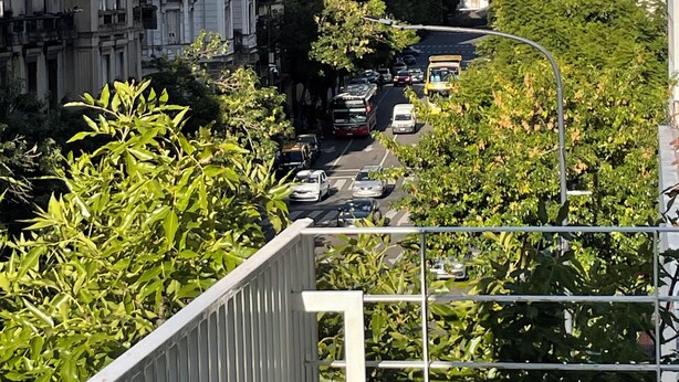 Una veduta di una strada con edifici, un autobus e un marciapiede.