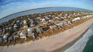 Vista aérea de una zona residencial costera con casas a lo largo de la playa.
