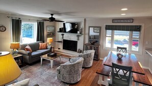 Una sala de estar con chimenea, una mesa de comedor y un televisor.