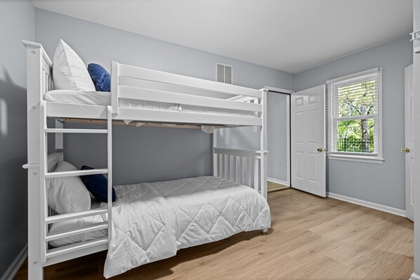 Dormitorio con literas, una puerta y una ventana.