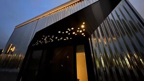 Un edificio moderno con techo inclinado y una serie de luces a lo largo del borde.