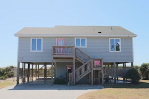 A two-story building with a balcony, a staircase, and a sign indicating it is a vacation rental. - Oceanfront 4BR Retreat with Private Beach Access-Discounted for weeks of 6/7 & 6 (Emerald Isle)