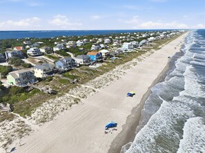 Un quartier résidentiel situé sur la côte, avec des maisons, une plage et une vue sur l’océan.
