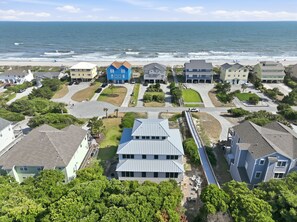 Une zone résidentielle côtière avec des maisons, une plage et un ciel dégagé.