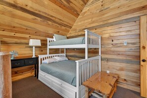 A bunk bed with a desk and chair, a small table, and a lamp in a wooden room. - Timberline Reserve | 2 Homes, Sleeps 28, Hot Tub, Boat Launch, Games! (Island Park)