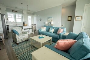 A living room with a sofa, coffee table, and a dining area with chairs.