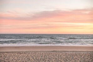 Platja amb onades i cel de ponent.