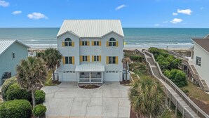 A two-story house with a balcony, a driveway, and a view of the ocean. - 4 BD| 4.5 Bath| Luxury Oceanfront Escape-Discounted week of 8/15 (Emerald Isle)