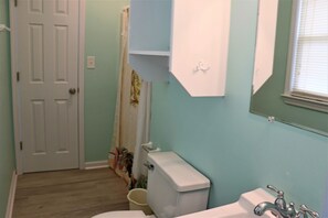 A bathroom with a toilet, sink, and a shower area. - 4BR Half-Duplex on Emerald Isle’s Oceanfront (Emerald Isle)