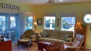 A living room with a sofa, two armchairs, a wooden coffee table, and a ceiling fan. - 3rd Row Home, Elevator & Ocean View (Emerald Isle)