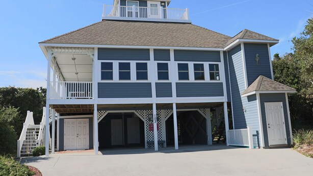 A two-story building with a balcony, a garage, and a small attached structure. - 3rd Row Home, Elevator & Ocean View (Emerald Isle)