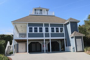 A two-story building with a balcony, a garage, and a small attached structure. - 3rd Row Home, Elevator & Ocean View (Emerald Isle)